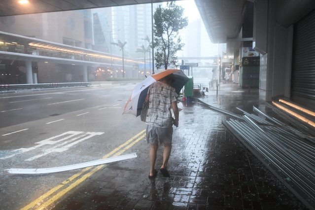 A woman walks past debris as Super Typhoon Ragasa hits the Central district in Hong Kong on September 24, 2025. Hong Kong's weather service issued the highest level of typhoon warning in the early hours, as Super Typhoon Ragasa brought powerful winds and lashing rain to the southern Chinese coast. (Photo by Peter Parks/AFP Photo)