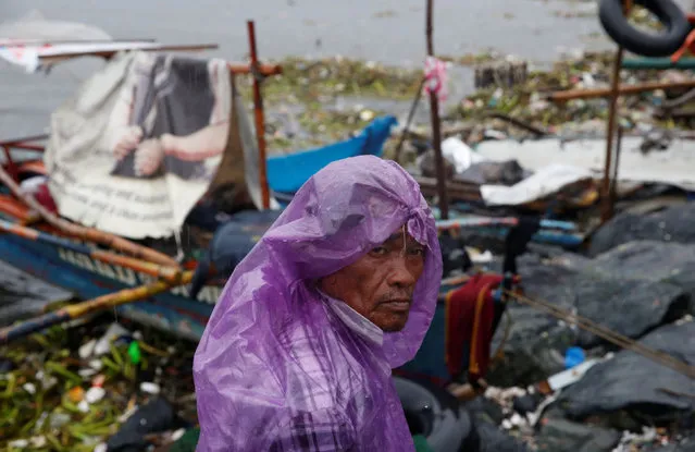 A fisherman stays next to his boat docked along the shore in Manila bay after Typhoon Sarika slammed central and northern Philippines, October 16, 2016. (Photo by Erik De Castro/Reuters)