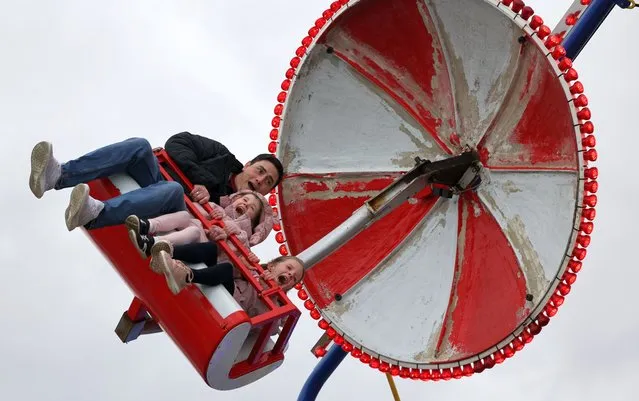 The Ennis family from Tallaght – Pierce and daughters Leah (5) and Hannah (7) – enjoy a fairground ride during the St Patrick's Festival weekend in Bray, Co Wicklow, Ireland on March 19, 2023. (Photo by Nick Bradshaw/The Irish Times)