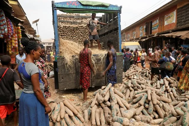 Men offload yam tubers from a truck at an open market, ahead of Nigeria's Presidential election in Awka, Anambra state, Nigeria on February 23, 2023. (Photo by Temilade Adelaja/Reuters)