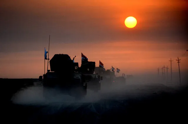 Pro-government forces drive in military vehicles in Iraq's eastern Salaheddin province, south of Hawijah, on October 10, 2016, as they clear the area in preparation for the push to retake the northern Iraqi city of Mosul, the last Islamic State (IS) group held city in Iraq. (Photo by Mahmoud al-Samarrai/AFP Photo)