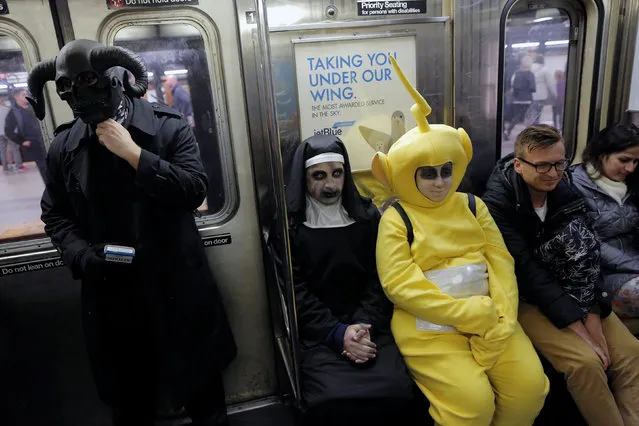 People in costume ride the subway on Halloween in Manhattan, New York, U.S., October 31, 2016. (Photo by Andrew Kelly/Reuters)