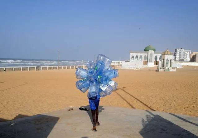 A boy carries jerricans to be filled at Khabrou Layene mosque, as the spread of the coronavirus disease (COVID-19) continues, in Yoff neighbourhood of Dakar, Senegal on January 12, 2021. (Photo by Zohra Bensemra/Reuters)