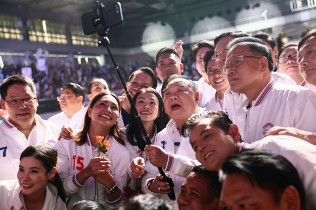 Thailand's Deputy Prime Minister Prawit Wongsuwan (C), the prime ministerial candidate for the Palang Pracharath Party, poses for photos with party members during their final campaign event in Bangkok on May 12, 2023, ahead of Thailand's May 14 general election. (Photo by Jack Taylor/AFP Photo)