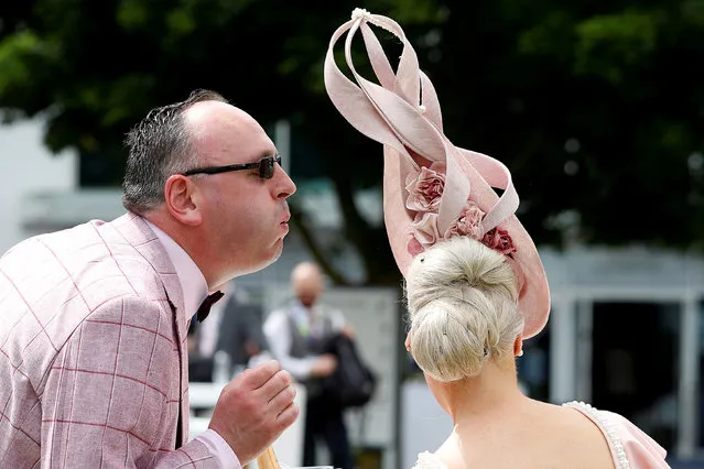 A racegoer removes an insect from a fellow racegoer's hair during the Investec Ladies Day at Epsom Downs on June 1, 2018 in Epsom, England. (Photo by Peter Nicholls/Reuters)