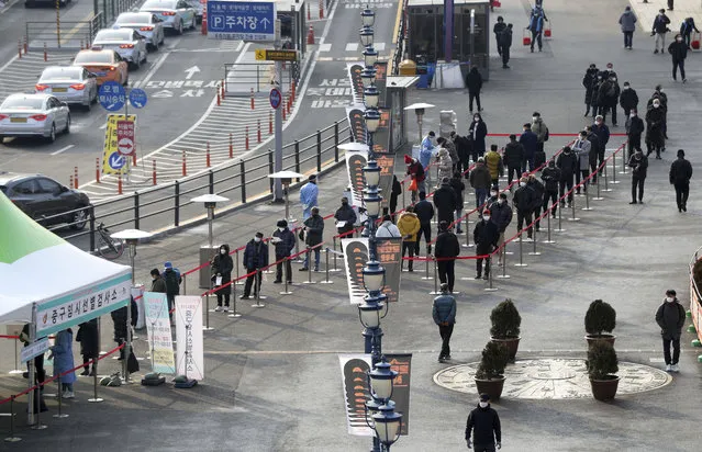 People queue in line to wait for coronavirus testing while maintaining social distancing at coronavirus testing site in Seoul, South Korea, Saturday, December 26, 2020. (Photo by Hong Hyosik/Newsis via AP Photo)