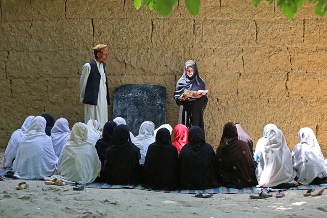 Afghan school girls attend a class at an open air primary school in Khogyani district of Nangarhar province on May 14, 2023. (Photo by Shafiullah Kakar/AFP Photo)