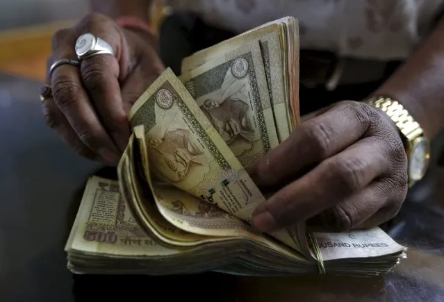 A money lender counts Indian rupee currency notes at his shop in Ahmedabad, India, in this May 6, 2015 file photo. China's accession to the International Monetary Fund's elite has left behind India, whose cautious approach to liberalisation means the rupee is unlikely to be a viable candidate for reserve currency status for at least a decade. (Photo by Amit Dave/Reuters)
