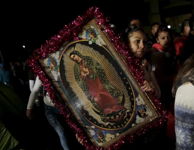 A pilgrim holds up an image of the Virgin of Guadalupe inside the Basilica of Guadalupe during the annual pilgrimage in honor of the Virgin of Guadalupe, patron saint of Mexican Catholics, in Mexico City, Mexico December 11, 2015. (Photo by Henry Romero/Reuters)