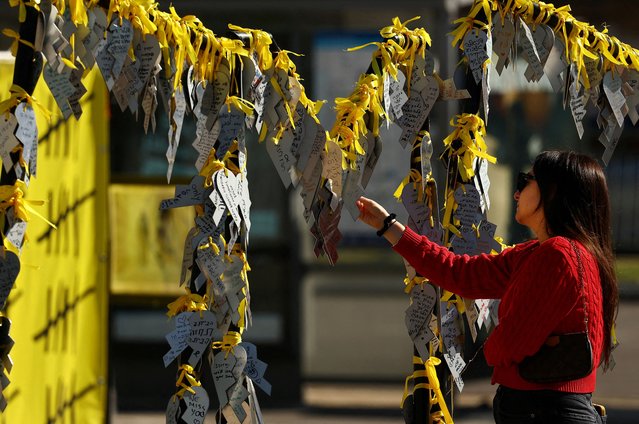 A woman reads messages written on broken heart cutouts for the hostages kidnapped during the deadly October 7, 2023 attack by Hamas, in Tel Aviv, Israel, on December 23, 2024. (Photo by Kai Pfaffenbach/Reuters)
