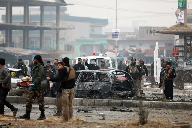 Afghan security personnel inspect the site of a bombing attack in Kabul, Afghanistan, Sunday, December 20, 2020. The strong car bomb explosion rocked the capital Kabul city on Sunday morning, killing multiple people, said a government official. (Photo by Rahmat Gul/AP Photo)