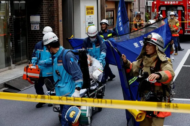An injured person is transported from the site of an apparent explosion near Shimbashi station in Tokyo, Japan on July 3, 2023. (Photo by Issei Kato/Reuters)