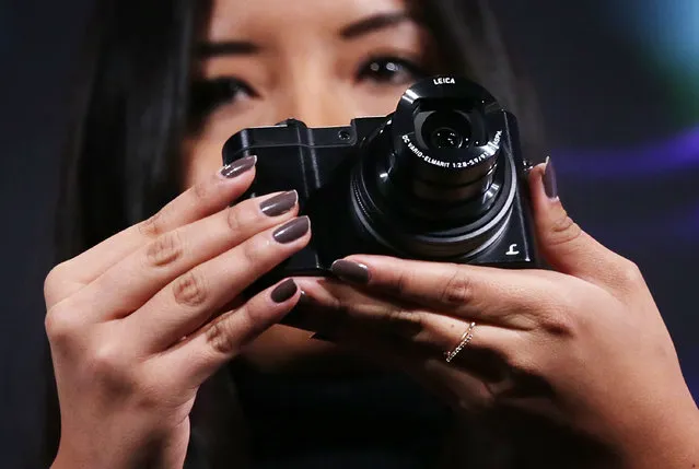 A woman holds up the Panasonic LUMIX DMC-ZS100 camera which features a 1-inch MOS sensor, a 10x zoom, 4K Photo and Post-Focus during a press event for CES 2016 at the Mandalay Bay Convention Center on January 5, 2016 in Las Vegas, Nevada. (Photo by Alex Wong/Getty Images)
