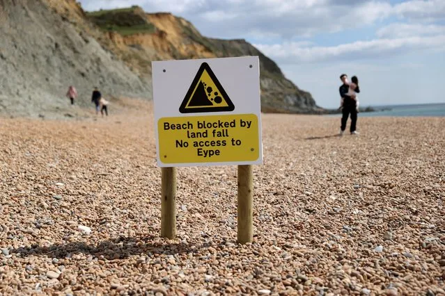 Signs are seen on the beach after a cliff collapsed near the village of Seatown, Dorset, Britain, April 16, 2021. (Photo by Carl Recine/Reuters)