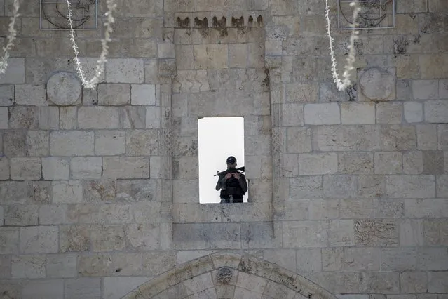 An Israeli police personnel guards on the walls of Jerusalem's old city during the second Friday prayer of the Ramadan, 23 April 2021. Muslims around the world celebrate the holy month of Ramadan by praying during the night time and abstaining from eating, drinking, and sexual acts during the period between sunrise and sunset. Ramadan is the ninth month in the Islamic calendar and it is believed that the revelation of the first verse in Koran was during its last 10 nights. (Photo by Atef Safadi/EPA/EFE)