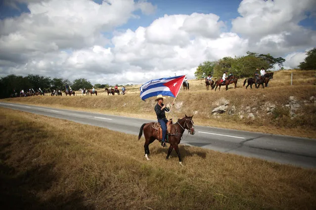 Cowboys wait along a road for the ashes of Cuba's former President Fidel Castro to pass during a  journey to the eastern city of Santiago de Cuba, in Cascorro, Cuba, December 2, 2016. (Photo by Alexandre Meneghini/Reuters)