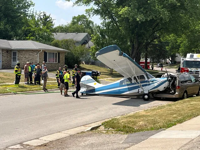 Emergency personnel work at the site where a small plane crashed on a residential street in Waunakee, Wisconsin, U.S., June 21, 2023 in this picture obtained from social media. (Photo by Matthew Cash via Reuters)