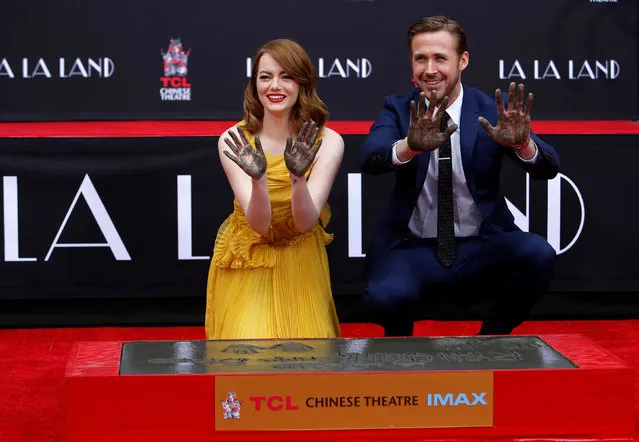 Actors Emma Stone and Ryan Gosling show their hands after placing them in cement during a ceremony in the forecourt of the TCL Chinese theatre in Hollywood, California U.S., December 7, 2016. (Photo by Mario Anzuoni/Reuters)