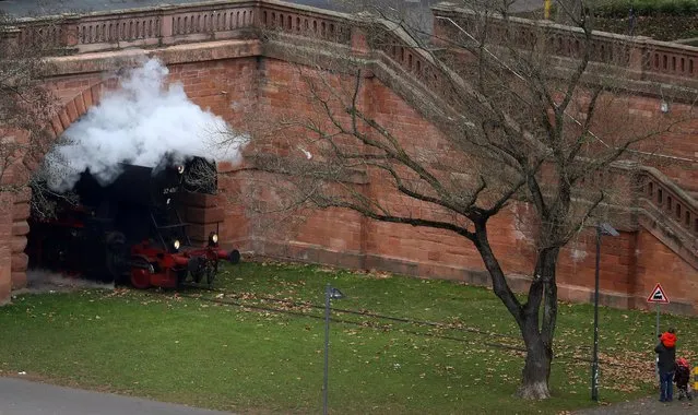 A man and his children look at a historic steam engine passing by on the museum rail track along the bank of river Main in Frankfurt, Germany December 11, 2016. (Photo by Kai Pfaffenbach/Reuters)