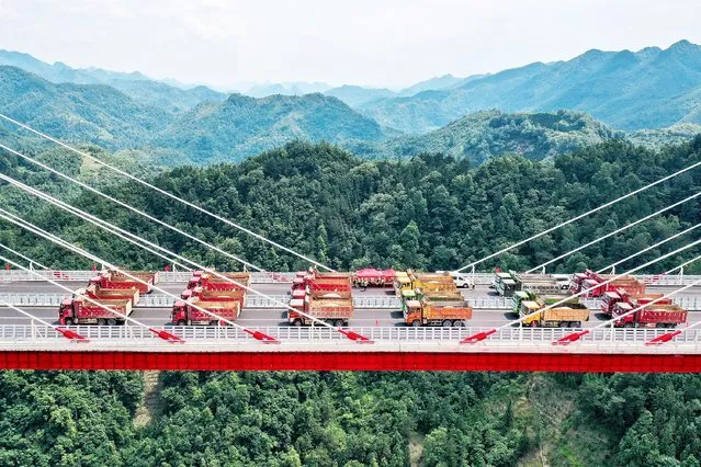 Trucks conduct a load test on the 1,720-meter Yunwu Bridge of Duyun-Anshun Expressway at Yunwu Town on June 8, 2021 in Guiding County, Qiannan Buyei and Miao Autonomous Prefecture, Guizhou Province of China. The load test used 24 trucks, weighing 35 tons each and 840 tons in total, to check whether the quality and working performance of the bridge are in accordance with the design. The cable towers of the bridge are designed as H-shaped reinforced concrete structures with heights of 273 meters and 300 meters respectively. This is the control project of Duyun-Anshun Expressway. (Photo by Qu Honglun/China News Service via Getty Images)