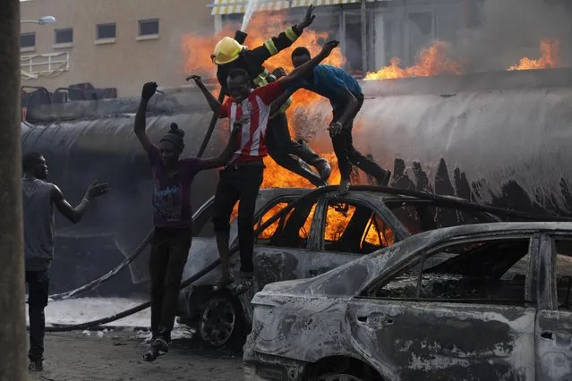 A firefighter and helpers flee as the try to contain a fire at a petrol station in Lagos, Nigeria on Thursday, March 26, 2015. (Photo by Sunday Alamba/AP Photo)