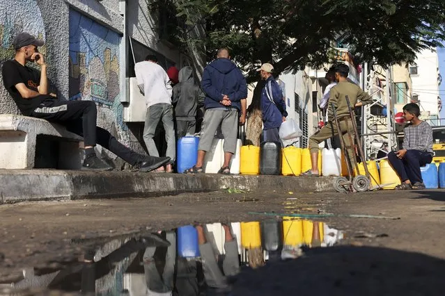 Palestinians queue for clean water in Rafah in the southern Gaza Strip on November 18, 2023, amid ongoing battles between Israel and the Palestinian group Hamas. (Photo by Mohammed Abed/AFP Photo)