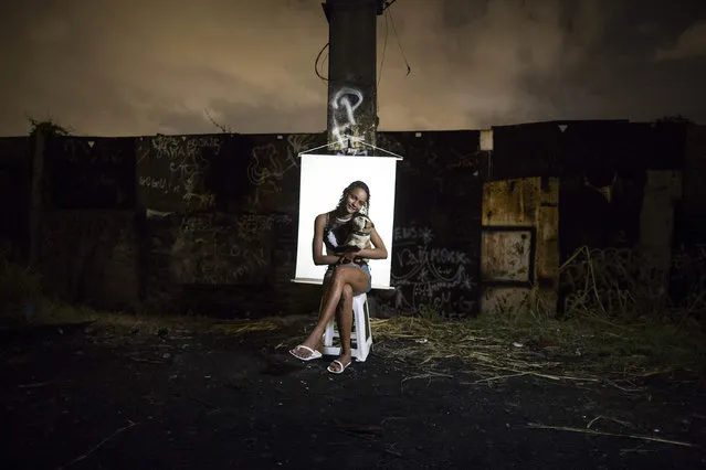 In this March 18, 2015 photo, Ketellin Silva 17, poses for a portrait in an open-air crack cocaine market, known as a “cracolandia” or crackland, where users can buy crack, and smoke it in plain sight, day or night, in Rio de Janeiro, Brazil. Silva, the mother of a 3-year-old girl, holds a stuffed toy dog she says belongs to her premature infant son who remains hospitalized. (Photo by Felipe Dana/AP Photo)