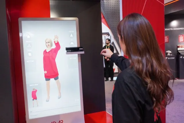 An employee of Chinese tech giant JD.com shows an augmented reality system that allows customers to virtually try on clothing at shops, part of the high-tech retail marketplace at the 2019 Consumer Electronic Show in Las Vegas on January 8, 2019. (Photo by Robert Lever/AFP Photo)