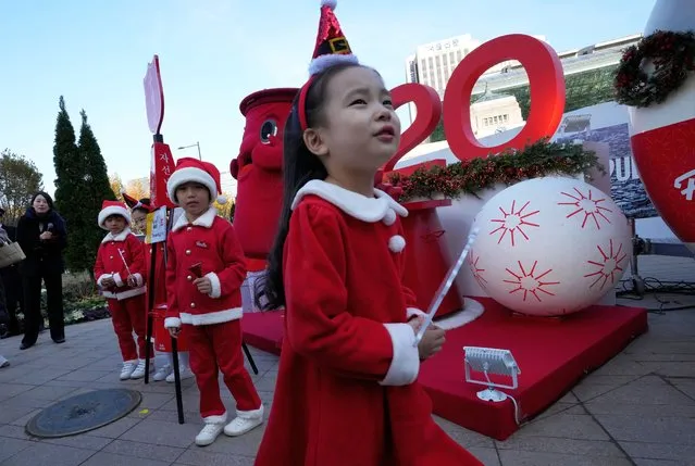 Children wearing Santa Claus outfits leave after attending a ceremony by the Salvation Army to prepare charity pots for a year-end fundraising campaign for the underprivileged in Seoul, South Korea, Tuesday, November 28, 2023. (Photo by Ahn Young-joon/AP Photo)