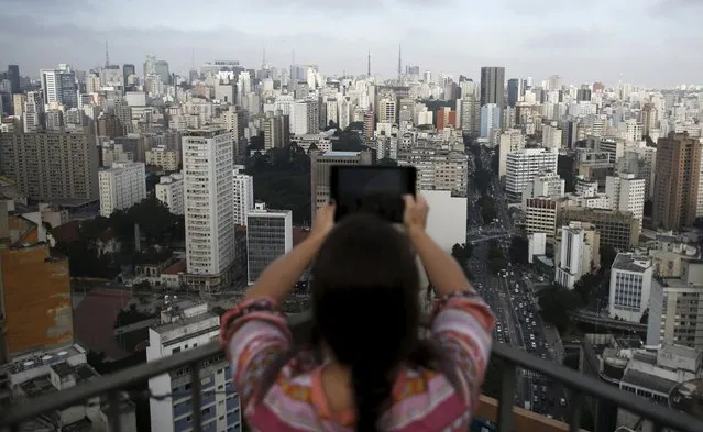 A woman takes a picture of the city of Sao Paulo April 9, 2015. (Photo by Nacho Doce/Reuters)