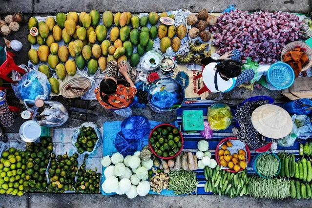 This aerial photo shows vendors selling vegetable at Vi Thanh market in Hau Giang province on October 25, 2023. (Photo by Nhac Nguyen/AFP Photo)