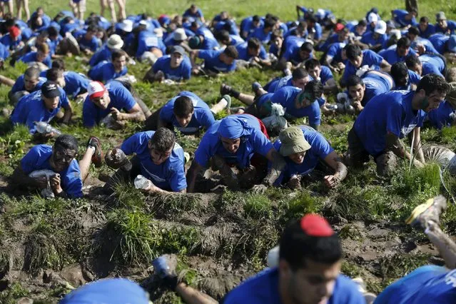 Israeli teenagers crawl through mud as they participate in an annual combat fitness training competition, as part of their preparations ahead of their compulsory army service, near Kibbutz Yakum, central Israel February 19, 2016. (Photo by Baz Ratner/Reuters)