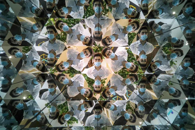 A visitor peeks into a kaleidoscope optical illusion installation, at the Illusion Museum in Arbil, the capital of Iraq's northern autonomous Kurdish region, on April 26, 2021. (Photo by Safin Hamed/AFP Photo)
