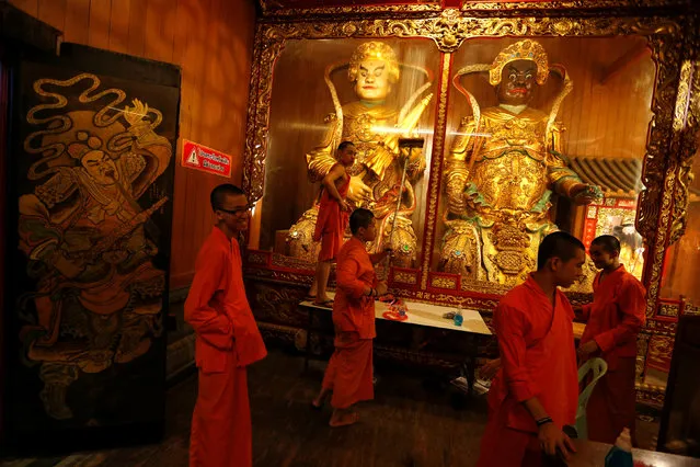 Buddhist monks clean a showcase inside the Wat Mangkon temple prior to Chinese New Year celebrations in Chinatown, Bangkok, Thailand January 24, 2017. (Photo by Jorge Silva/Reuters)