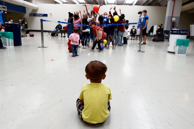 A child sits on the floor at Fiumicino Airport, as Afghan evacuees arrive in Italy following their journey from Kabul, in Rome, Italy, August 24, 2021. (Photo by Guglielmo Mangiapane/Reuters)