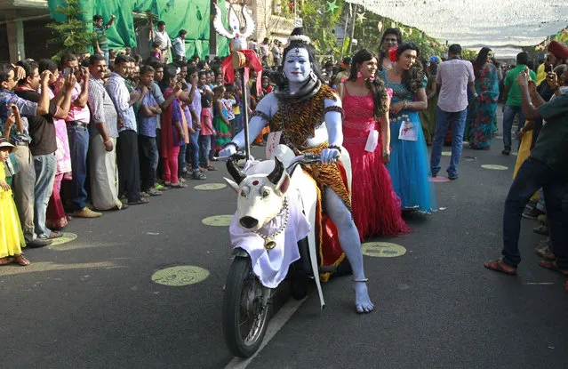 A performer dressed as Shiva sits on a motorcycle as he participates in the 30th Cochin Carnival at Fort Kochi in Kochi January 1, 2014. The Carnival is held annually to welcome the start of the New Year. (Photo by Sivaram V/Reuters)