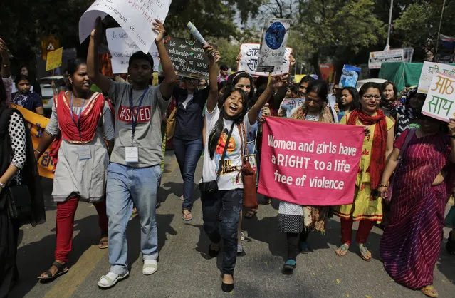 Women's rights activists hold banners and placards as they march on International Women's Day in New Delhi, India, Tuesday, March 8, 2016. Activists were demanding that the Women's Reservation Bill, which would reserve Indian legislative seats for women, be passed by the Parliament among other demands. (Photo by Altaf Qadri/AP Photo)