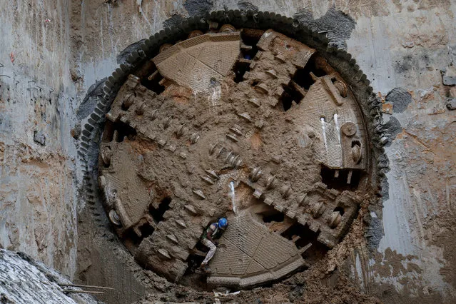 A construction worker comes through a Tunnel Boring Machine (TBM) breakthrough point after successfully building a tunnel for the metro train in Ahmedabad, India, February 25, 2019. (Photo by Amit Dave/Reuters)
