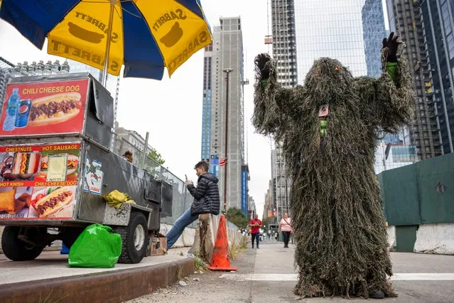 A cosplayer dressed as Swampman poses next to a food cart outside Day 3 of New York Comic Con at Javits Center on October 09, 2021 in New York City. Comic Con has returned this year after being cancelled in 2020 due to the coronavirus pandemic. (Photo by Alexi Rosenfeld/Getty Images)