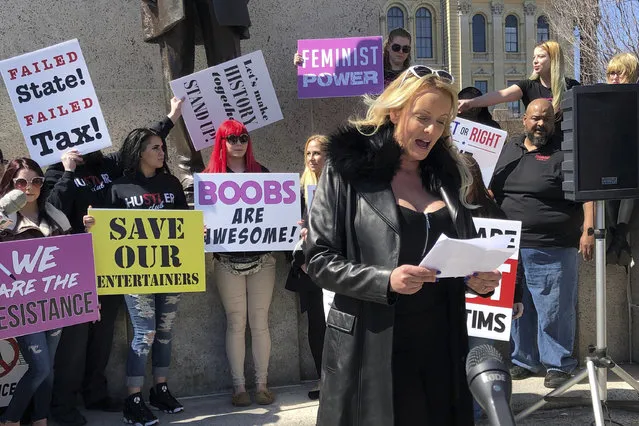 Adult film star Stormy Daniels reads a statement, protesting the Illinois surcharge on live adult entertainment centers, beneath the statue of Abraham Lincoln at the state Capitol, Friday, March 22, 2019 in Springfield, Ill. The actress famous for her alleged affair with Donald Trump before he became president read a two-minute statement before she was whisked off to a local strip club to sign copies of her book. Daniels, whose real name is Stephanie Clifford, says the tax unfairly ties nude dancing to violence against women and that it “takes money out of the g-strings of hardworking young dancers”. (Photo by John O'Connor/AP Photo)