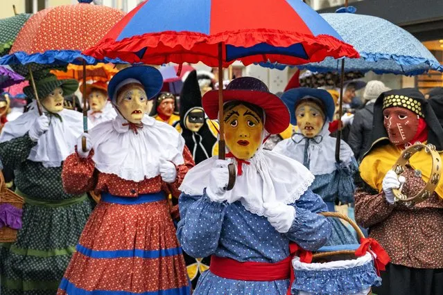 So-called Nuessler, men or boys in traditional costumes and masks that are derived from those worn by the characters in the Venetian Commedia dell'Arte, parade through the streets of Brunnen, Switzerland, 08 January 2024, marking the opening of the carnival season. (Photo by Urs Flueeler/EPA)