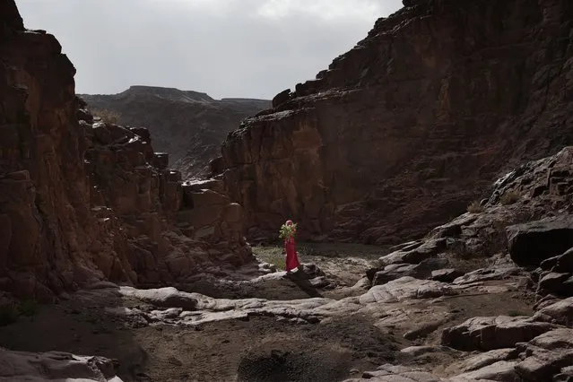 In this March 29, 2019 photo, a Bedouin girl holds plants she picked for her mother in the mountains near Wadi Sahw, Abu Zenima, in South Sinai, Egypt. Four Bedouin women are for the first time leading tours in Egypt’s Sinai Peninsula, breaking new ground in their deeply conservative community, where women almost never work outside the home or interact with outsiders. The guides talk about the local plants and herbs, the history and legends of the area and point out the borders of the area’s tribes. (Photo by Nariman El-Mofty/AP Photo)