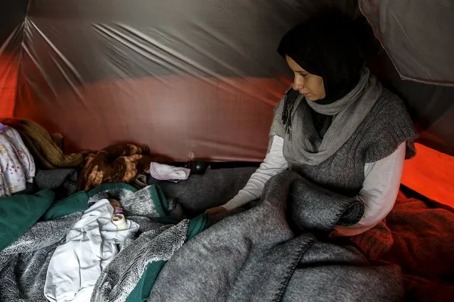 Syrian refugee Shukria Al Bakr, 19, from Idlib, Syria, sits next to her ten-day-old newborn baby Zaynab inside a tent at a makeshift camp for refugees and migrants at the Greek-Macedonian border, near the village of Idomeni, Greece, in this file photo taken March 17, 2016. (Photo by Alkis Konstantinidis/Reuters)