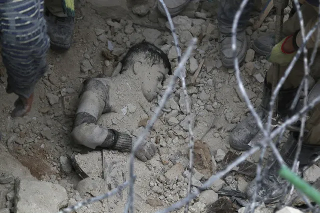 Men try to pull a body from under the rubble at a site hit by what activists said was shelling by forces loyal to Syria's President Bashar al-Assad in Aleppo's district of al-Sukari March 8, 2014. (Photo by Hosam Katan/Reuters)