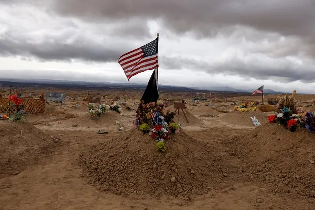 A U.S. flag flutters above the gravesite of a U.S. Marines veteran at the Naschitti Cemetery on Navajo Nation federal trust land outside Gallup, New Mexico, U.S., December 7, 2021. (Photo by Shannon Stapleton/Reuters)
