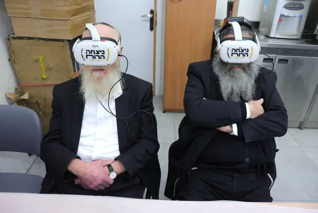 Ultra-Orthodox Jews use virtual reality headsets to watch a tour of the Auschwitz-Birkenau extermination camp in Poland, at a Yeshiva in Jerusalem, Israel, 03 January 2023. The initiative, called “Victory of the Spirit”, offers a virtual tour filmed in 360 degrees mainly for the Ultra-Orthodox public in Israel who do not participate in the state visits to the Auschwitz-Birkenau extermination camp. (Photo by Abir Sultan/EPA/EFE)