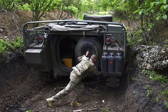 A Ukrainian serviceman with the 65th Brigade opens the door of his armored vehicle at the frontline in the Zaporizhzhia region, Ukraine, on Sunday, April 21, 2024. (Photo by Andriy Andriyenko/AP Photo)