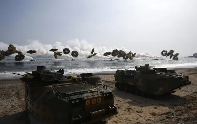 Amphibious assault vehicles of the South Korean Marine Corps throw smoke bombs as they move to land on shore during a U.S.-South Korea joint landing operation drill in Pohang March 31, 2014. (Photo by Kim Hong-Ji/Reuters)