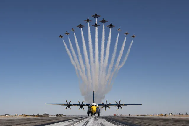 This handout photo courtesy of the US Air Force shows the United States Air Force Air Demonstration Squadron “Thunderbirds” and the United States Navy Flight Demonstration Squadron, the Blue Angels, debut the Super Delta formation consisting of six F-16 Fighting Falcons and six F/A-18 Super Hornets over a C-130J Super Hercules at Naval Air Facility El Centro, March 2, 2021. This is the first time the demo teams performed the formation which grew out of joint training opportunities held in 2020 and 2021. (Photo by Andrew D. Sarver/US Air Force/AFP Photo)