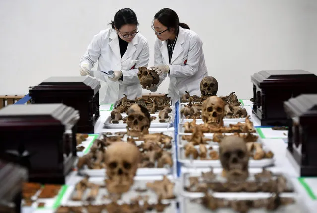 Members of South Korea' s Agency for KIA Recovery and Identification check the remains of Chinese soldiers, who fought during the Korean War, during ceremonial rites to place the remains at a temporary military ossuary in Incheon, west of Seoul, on March 20, 2017 The remains of 28 Chinese soldiers killed during the 1950-53 Korean War will return home from South Korea on March 22 for permanent burial. (Photo by Jung Yeon-Je/Reuters)